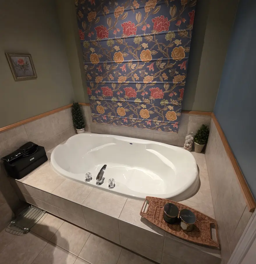 Avant : bain jacuzzi encastré en céramique beige avec papier peint floral.